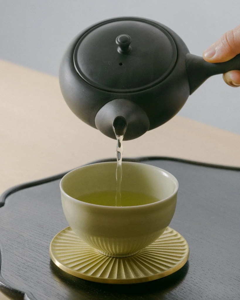 Japanese green tea being poured into a cup